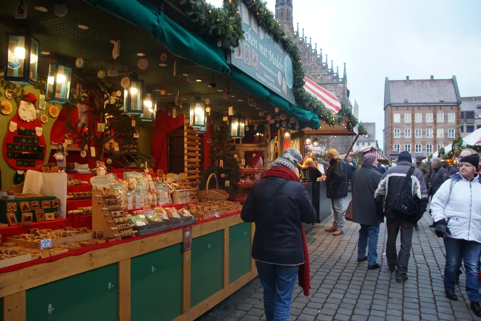Visitors walk past the wooden stalls of the Christkindlesmarkt in Nuremberg, 2022