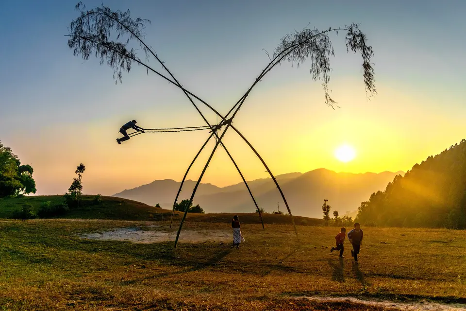 Un linge ping, el columpio de bambú levantado para el Dashain, contra el cielo del atardecer