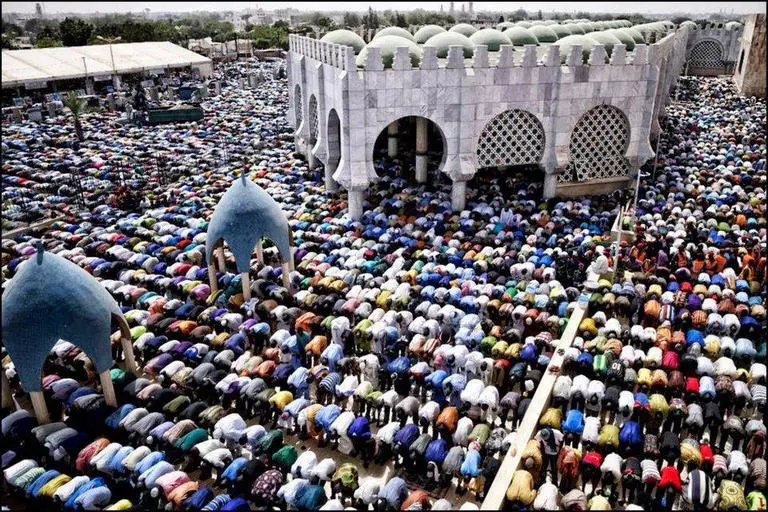 Rows of worshippers pray beside the Great Mosque of Touba during the Grand Magal