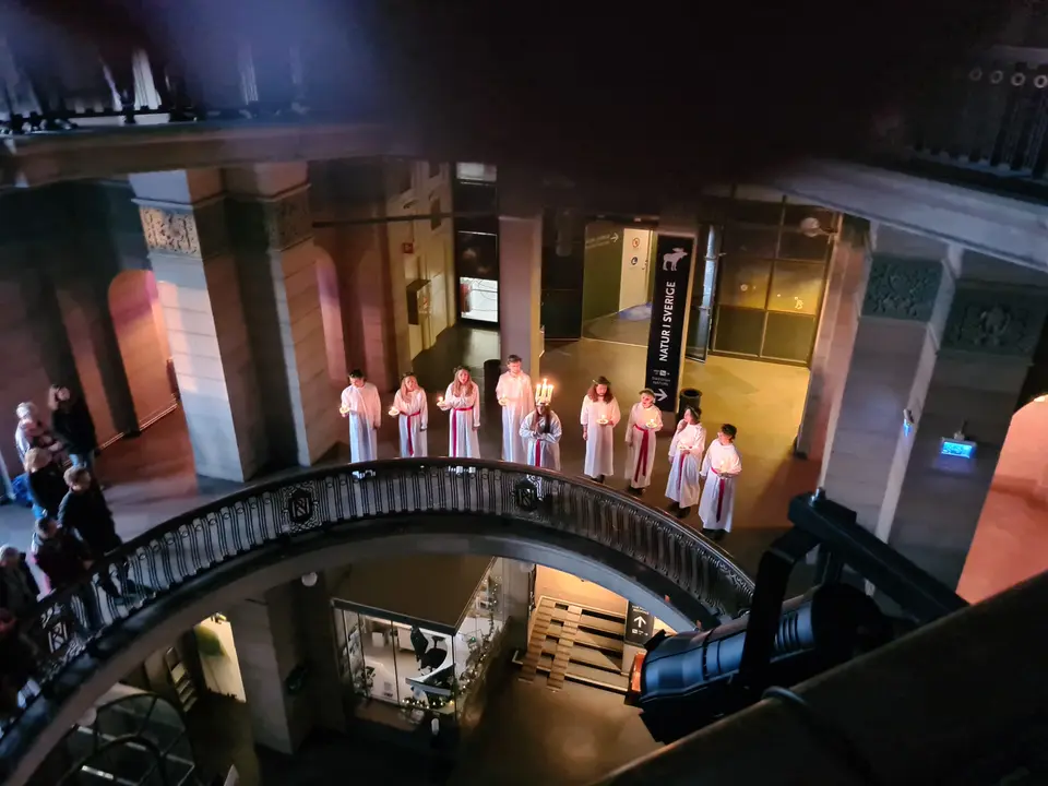 A Lucia procession in white gowns at the Swedish Museum of Natural History in Stockholm