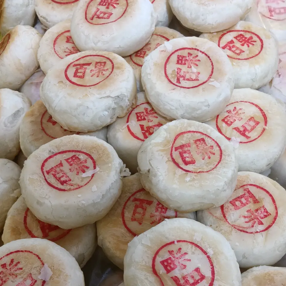 Setumpuk kue bulan gaya Suzhou berkulit pucat berlapis-lapis, masing-masing bercap tinta merah