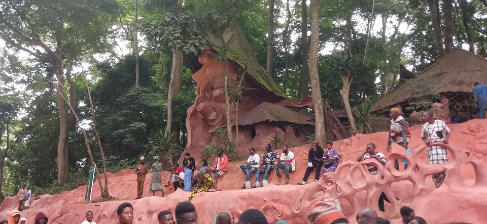 Visitors sit among the sculptures of the Osun Sacred Grove during the festival, 2023