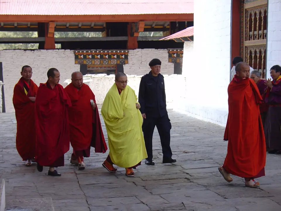 Der Je Khenpo im gelben Gewand geht zum Fest in Punakha, umgeben von Mönchen in Weinrot