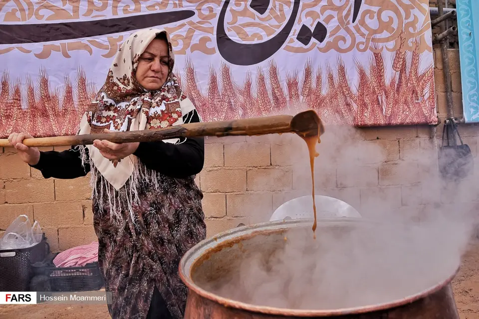 زنی پاروی بلندِ چوبی را از دیگِ مسیِ بخارگرفتهٔ سمنو بیرون میکشد، در جشنوارهٔ سمنوی درق، خراسان شمالی