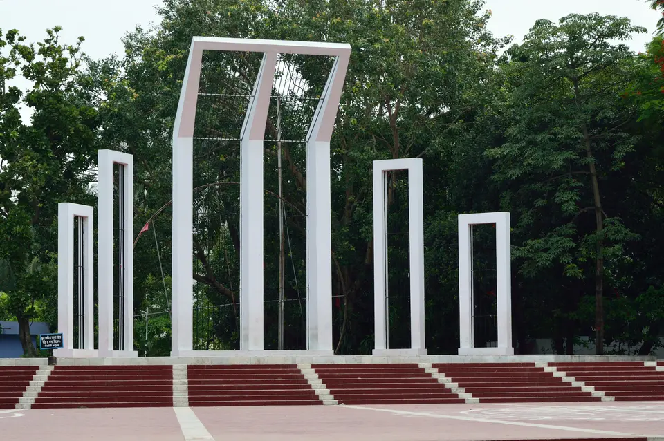 Le Shaheed Minar de Dacca : des colonnes de marbre blanc courbées autour d'une plus haute, au-dessus de larges marches rouges