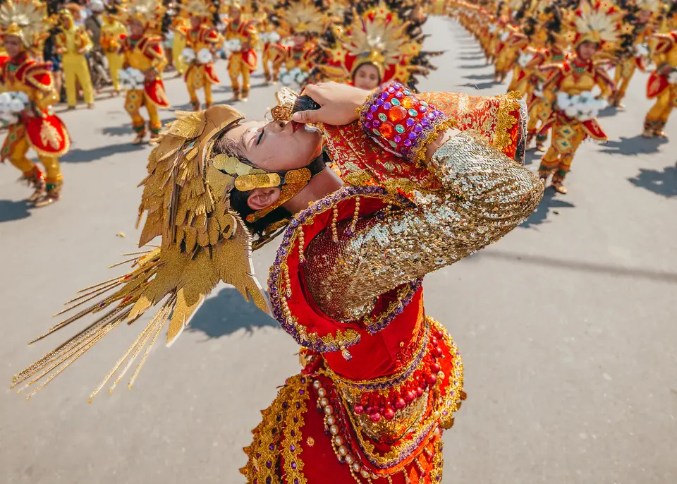 A Sinulog street-dance contingent in red and gold costumes, Cebu City, 2023