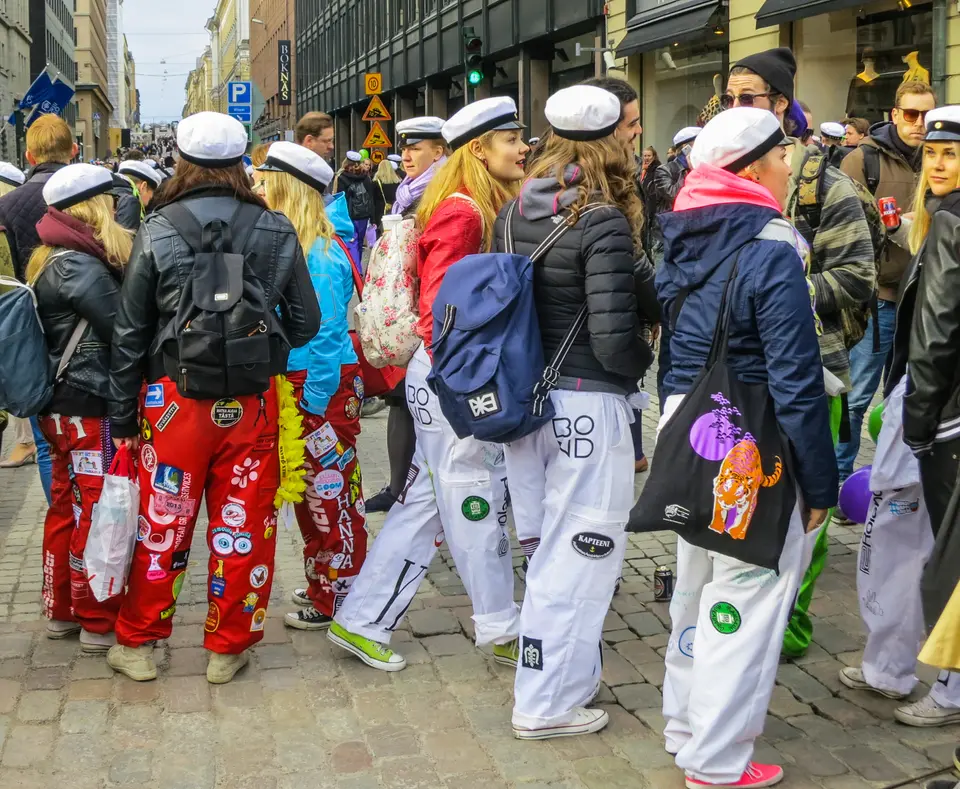 Students in white caps and patched coveralls on Vappu eve in Helsinki, 2016